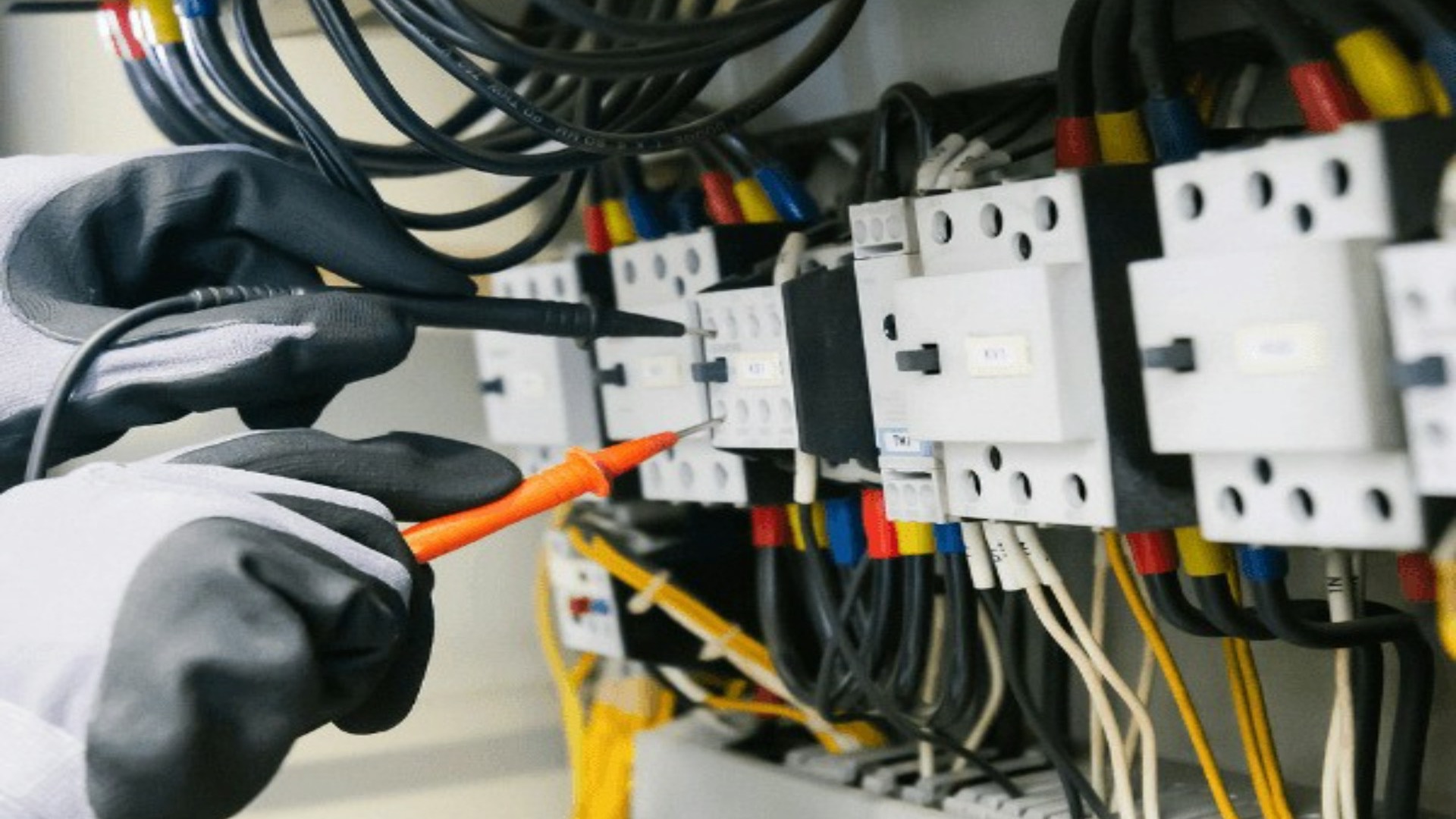 Elektriker misst an einem Zählerschrank mit Messgerät