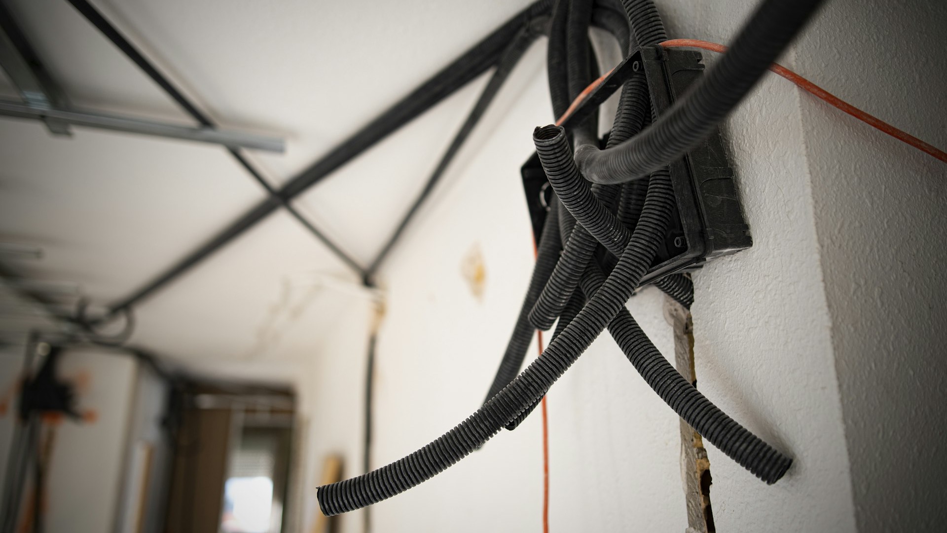 Elektroinstallation im Rohbau: Wellrohre und Unterputzdose in einer weißen Wand